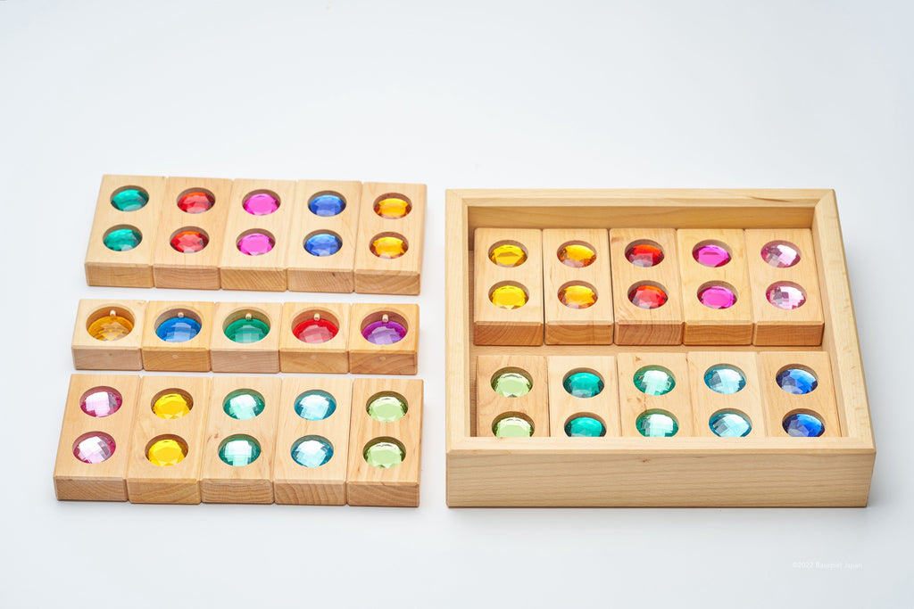 Bauspiel Colour Street blocks laid beside their wooden tray, showing the coloured View Blocks.
