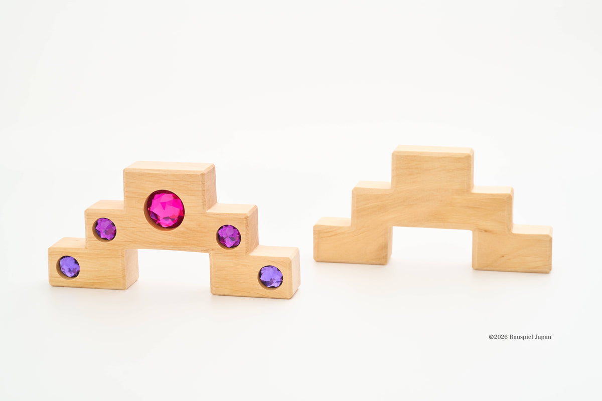 Front and back of Bauspiel staircase blocks, showing coloured stones on the front and plain wood on the back.